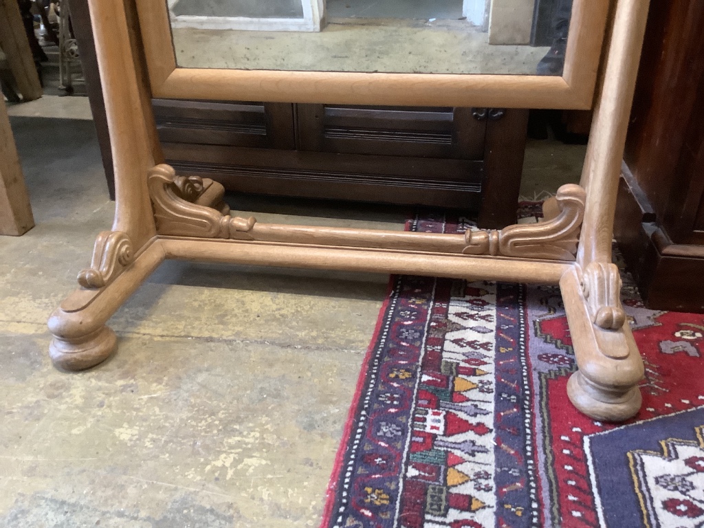 A large 19th century continental pale oak cheval mirror, with scrolling carved mounts, width 84cm, height 162cm